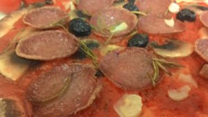 Pizza con setas tomate Salami aceitunas negras