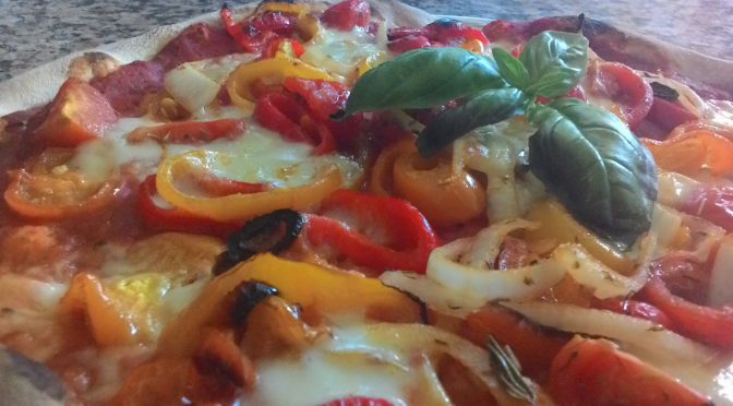 pizza de cebolla con pimientos tomates y mozzarella