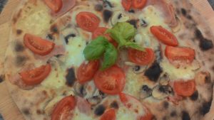 Pizza con Mozzarella Funghi Prosciutto e Pomodorini
