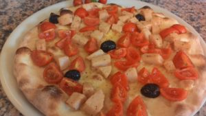 Focaccia with tomatoes cooked ham and black olives