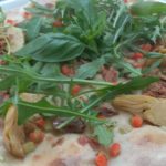 Pizza con atún setas alcachofas y rúcula