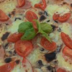 Pizza con Mozzarella Funghi Prosciutto e Pomodorini