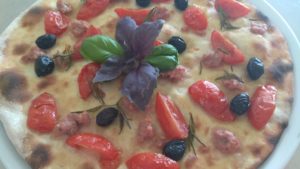 Focaccia con los tomates salchicha y aceitunas negras