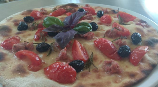 Focaccia con los tomates salchicha y aceitunas negras