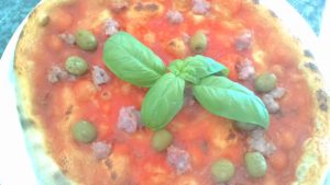 Pizza with sausage and green olives