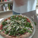 Cebola pizza com rúcula e parmesão