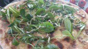 Pizza con pesto de oliva y almendra rúcula y Grana
