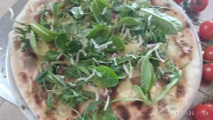 Pizza con pesto de oliva y almendra rúcula y Grana