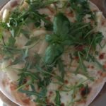 Pizza with mozzarella, gorgonzola, pears and rocket