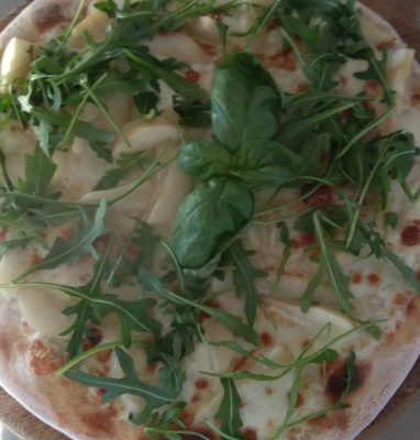 Pizza con mozzarella, gorgonzola, peras y rúcula