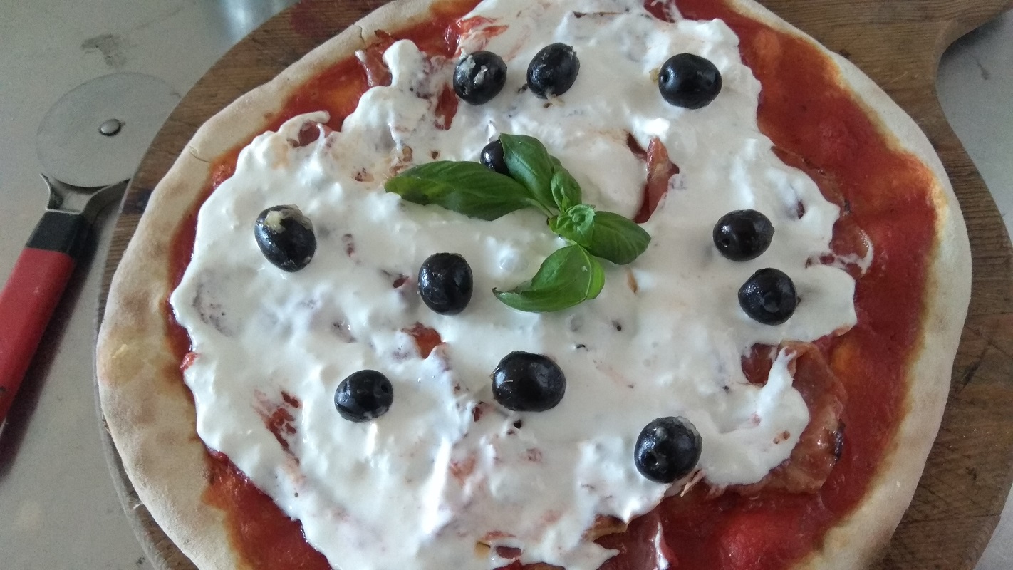 Pizza con Pomodoro Pancetta Mozzarella Stracciatella e olive Nere