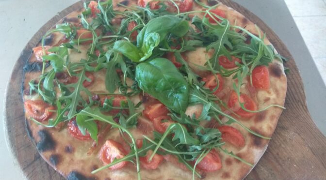 Focaccia with tomatoes, bacon and rocket